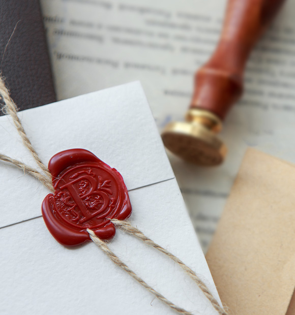 wax seal on letter with twine and wooden stamp resembling 8 decorative elements