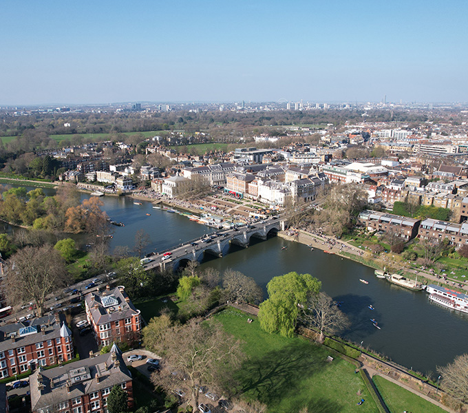 aerial view of a scenic city landscape featuring a river and a bridge surrounded by greenery and urban buildings capturing the essence of five picturesque elements